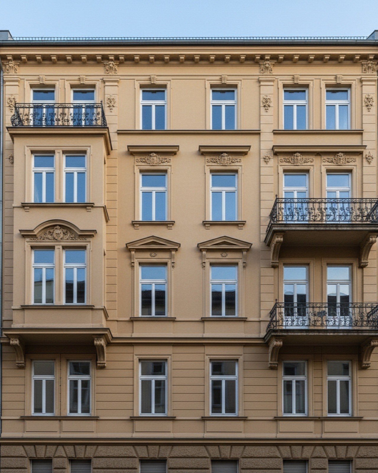 Fassade eines mehrgeschossigen Gründerzeit-Altbaus mit Stuckverzierungen und schmiedeeisernen Balkonen